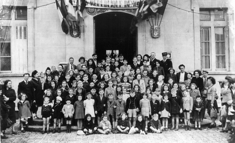 Groupe d'enfants et quelques adultes devant la mairie, 1945