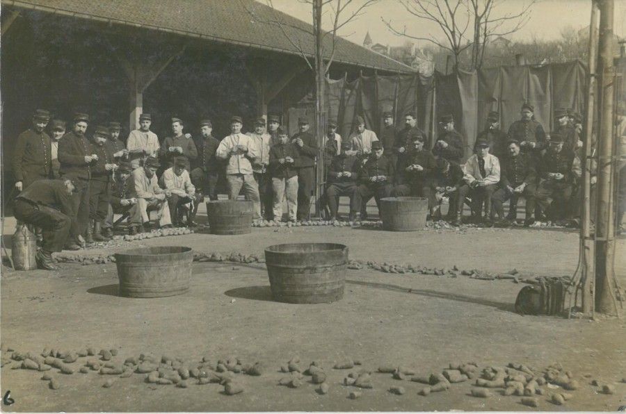 Carte-photo des soldats cantonnés à l'école Jules Ferry, corvée de patates, 1915.